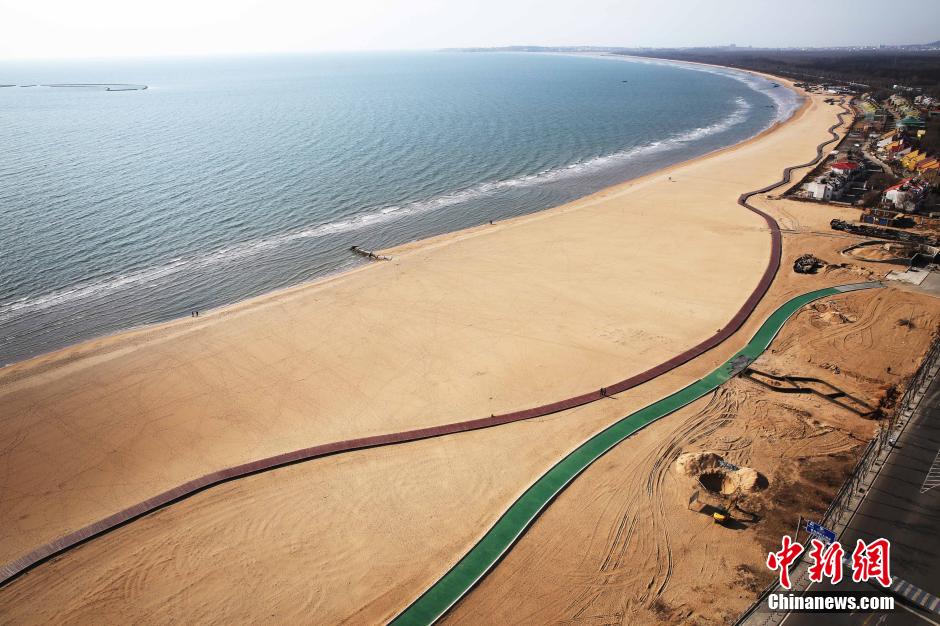 3月13日，秦皇島萬(wàn)米臨海沙灘木棧道。據(jù)了解，該木棧道全長(zhǎng)約4200米，與北戴河區(qū)原有的7500米木棧道對(duì)接后全線總長(zhǎng)度1.17萬(wàn)米，整個(gè)木棧道東起秦皇島體育基地游船碼頭，西至北戴河濕地公園，呈波浪形蜿蜒10.4公里海岸線。 中新社發(fā) 曹建雄 攝 CNSPHOTO